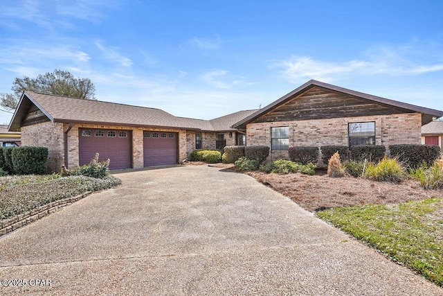 single story home featuring an attached garage, driveway, a shingled roof, and brick siding