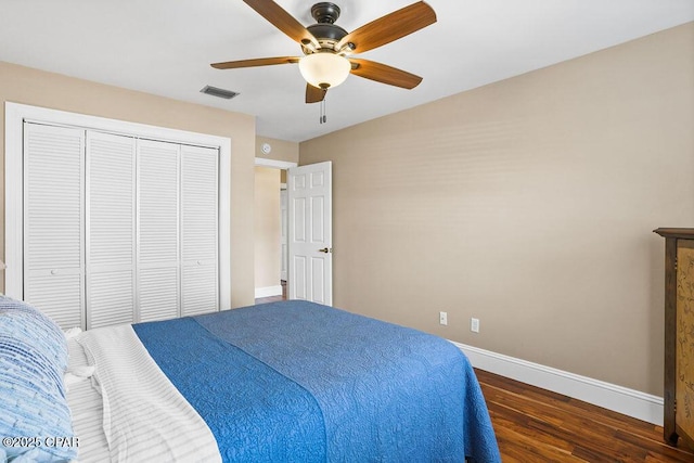 bedroom featuring visible vents, baseboards, a ceiling fan, wood finished floors, and a closet