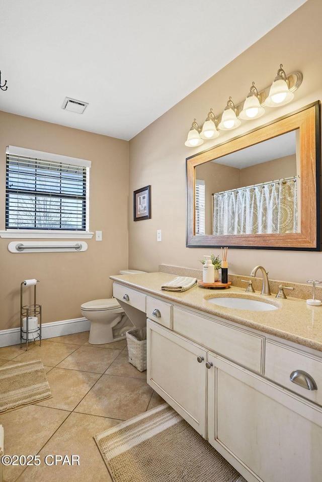 bathroom featuring toilet, vanity, baseboards, visible vents, and tile patterned floors