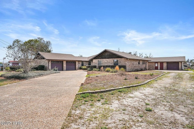 view of front of property featuring a garage, concrete driveway, and brick siding