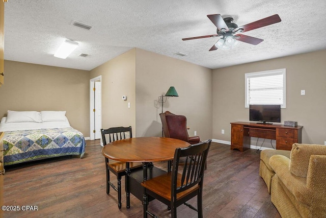 dining area with visible vents, baseboards, hardwood / wood-style flooring, ceiling fan, and a textured ceiling