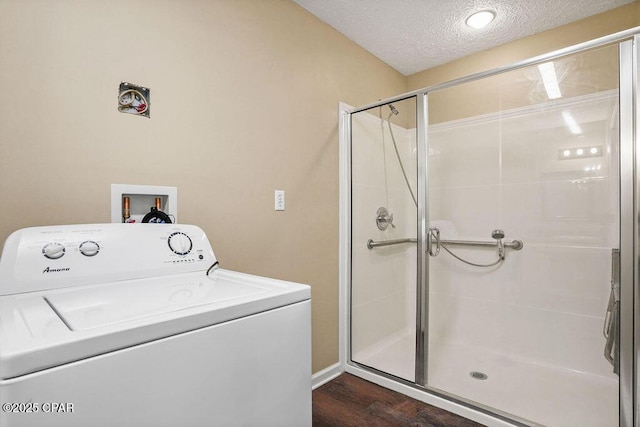 bathroom featuring a stall shower, washer / clothes dryer, and a textured ceiling