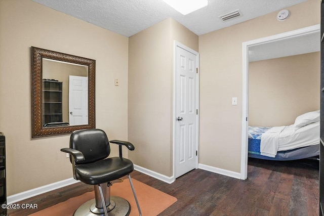 interior space featuring baseboards, a textured ceiling, visible vents, and wood finished floors