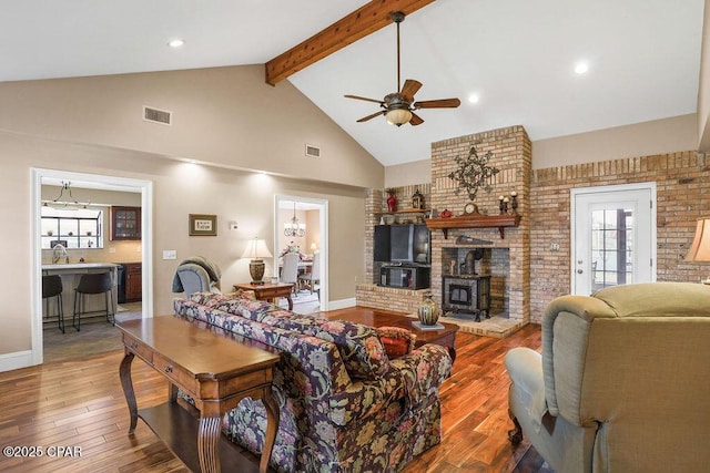 living room featuring beamed ceiling, hardwood / wood-style flooring, high vaulted ceiling, and visible vents