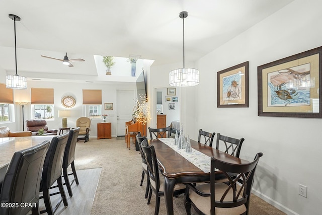 dining room with baseboards, ceiling fan, and light colored carpet