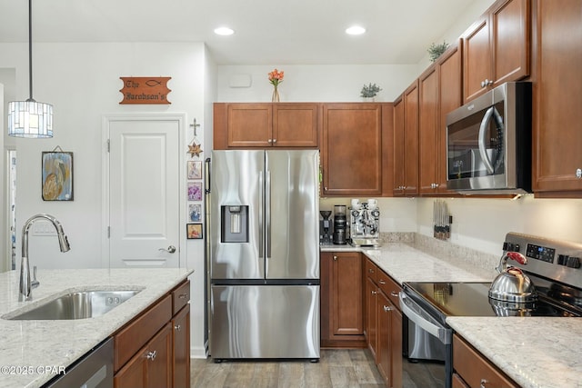 kitchen featuring appliances with stainless steel finishes, recessed lighting, a sink, and light stone countertops