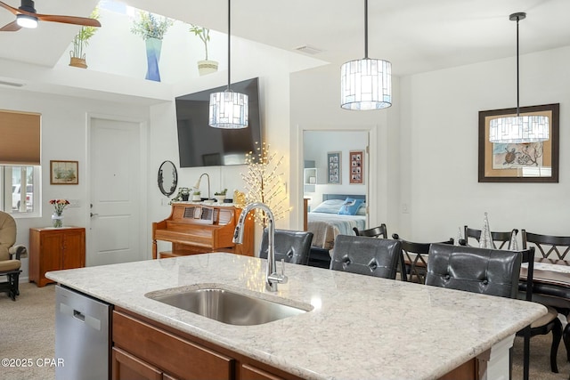 kitchen with light carpet, light stone counters, open floor plan, stainless steel dishwasher, and a sink