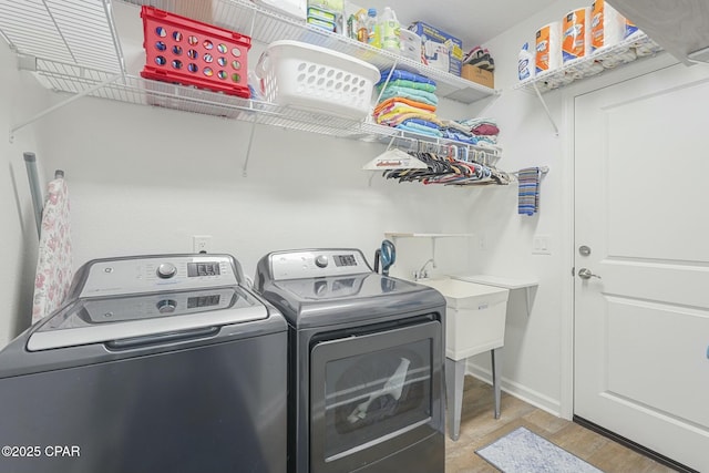 laundry room with light wood-style floors, laundry area, washer and clothes dryer, and baseboards