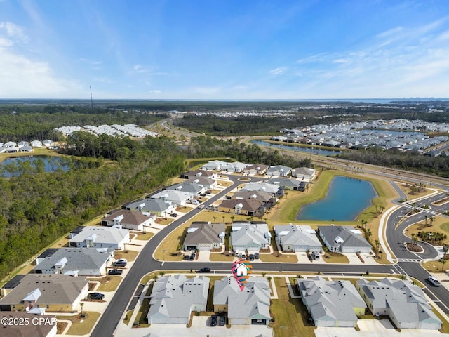 aerial view with a forest view, a water view, and a residential view