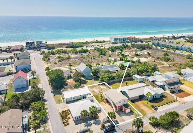 drone / aerial view featuring a water view, a residential view, and a view of the beach