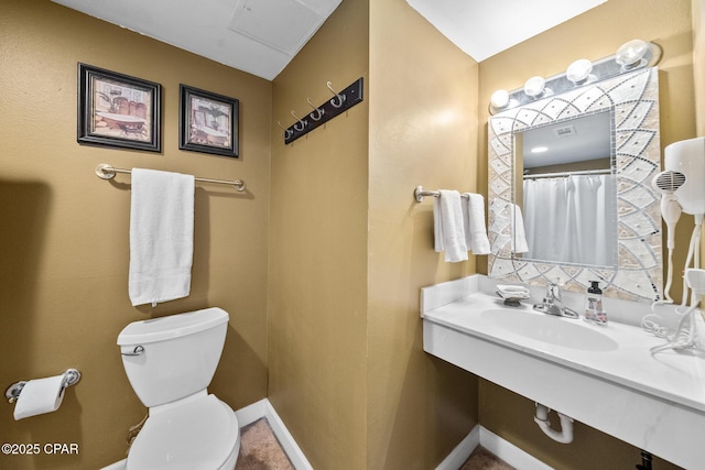 full bath featuring a sink, baseboards, and toilet