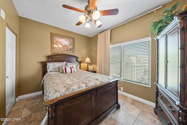 bedroom featuring light tile patterned floors, a ceiling fan, and baseboards