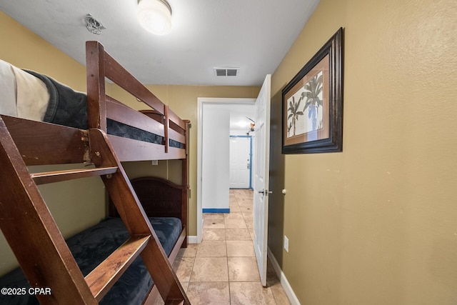 bedroom featuring light tile patterned floors, visible vents, and baseboards