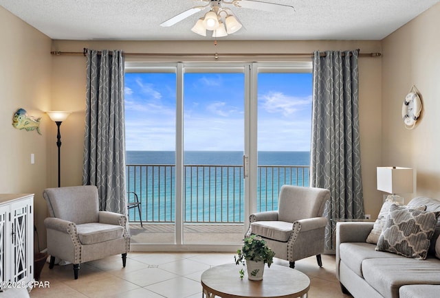 1160 Scenic Gulf Dr Unit A903, Miramar Beach, FL 32550 - living room with light tile patterned floors, a healthy amount of sunlight, a ceiling fan, and a water view