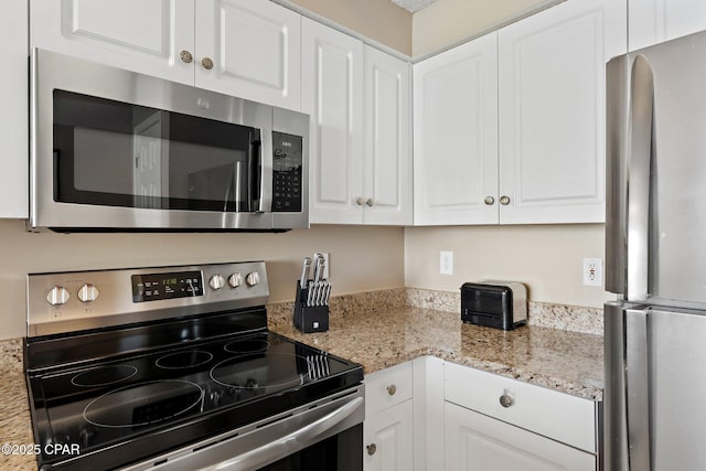 1160 Scenic Gulf Dr Unit A903, Miramar Beach, FL 32550 - kitchen with appliances with stainless steel finishes, white cabinetry, and light stone countertops
