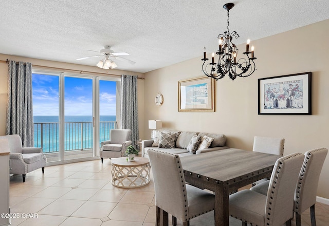 1160 Scenic Gulf Dr Unit A903, Miramar Beach, FL 32550 - dining area with ceiling fan with notable chandelier, a water view, and a textured ceiling