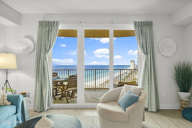 interior space featuring a water view, baseboards, and wood finished floors