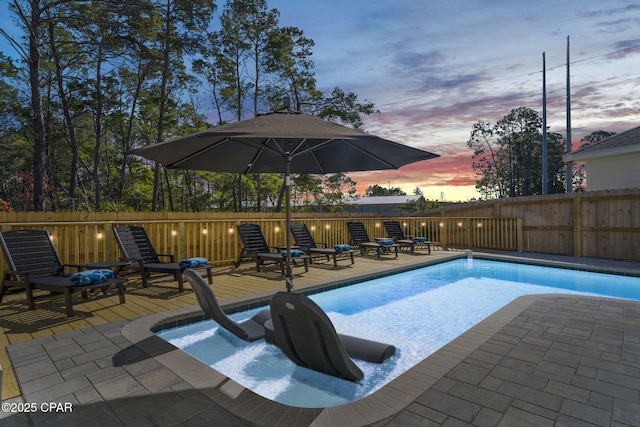 pool at dusk with fence and a fenced in pool