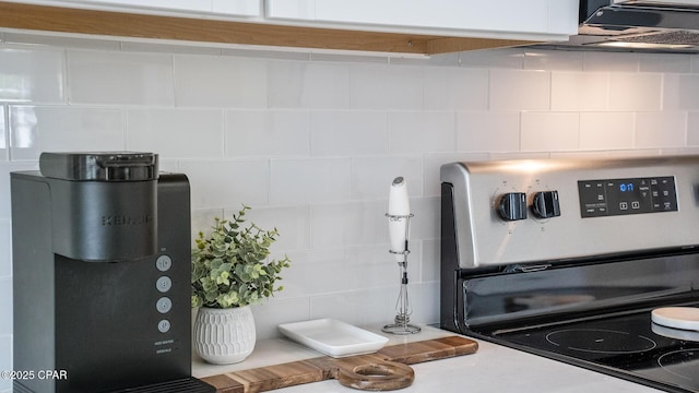 interior details featuring backsplash and stainless steel range with electric cooktop