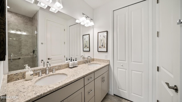 bathroom with double vanity, a stall shower, and a sink