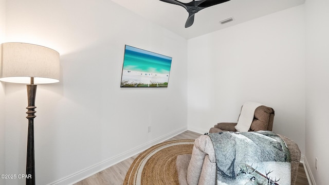 sitting room featuring visible vents, light wood-style flooring, and baseboards