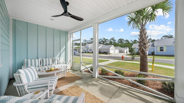 sunroom with ceiling fan and a residential view