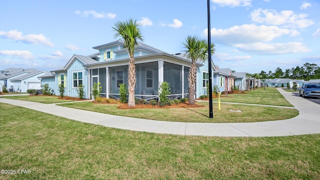 view of front of property with a front yard, a residential view, and a sunroom