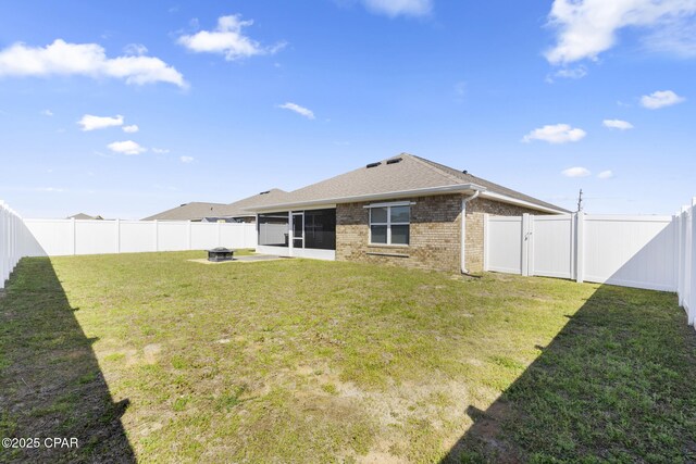 110 Spikes Cir, Southport, FL 32409 - rear view of property featuring a sunroom, brick siding, a fire pit, and a shingled roof