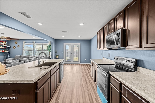 kitchen featuring dark brown cabinetry, a sink, visible vents, french doors, and appliances with stainless steel finishes