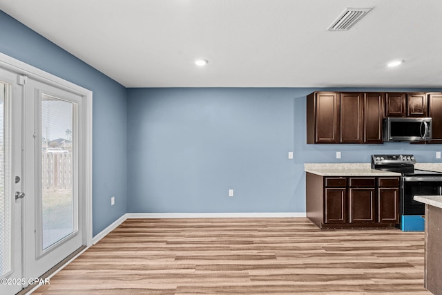 kitchen with visible vents, light wood-style floors, dark brown cabinets, appliances with stainless steel finishes, and light countertops