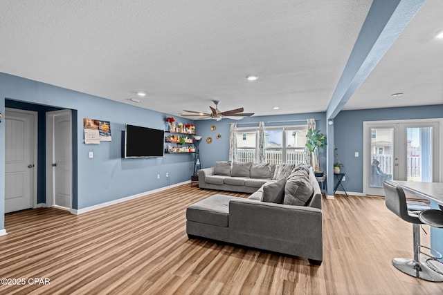 living room with a textured ceiling, french doors, plenty of natural light, and baseboards