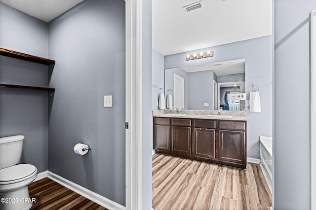 full bathroom featuring baseboards, visible vents, toilet, wood finished floors, and a sink