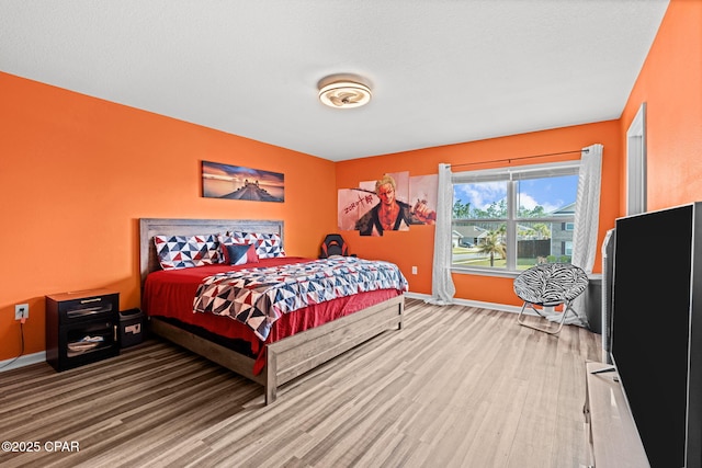 bedroom featuring wood finished floors and baseboards