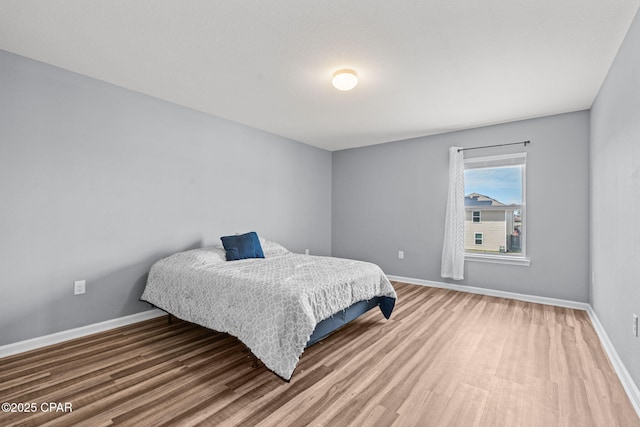 bedroom with wood finished floors and baseboards