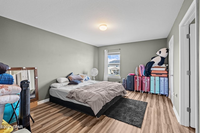 bedroom featuring baseboards and wood finished floors