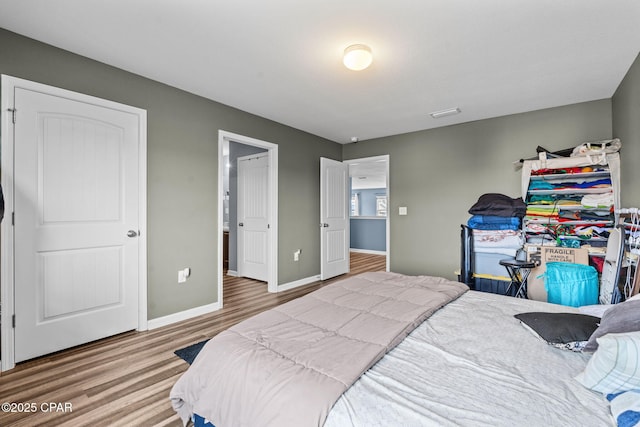 bedroom with baseboards and wood finished floors