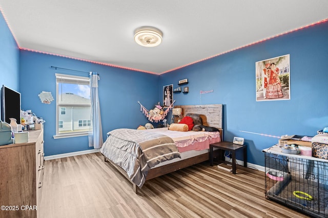 bedroom featuring baseboards and wood finished floors