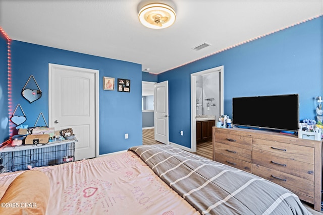 bedroom featuring visible vents, connected bathroom, and baseboards