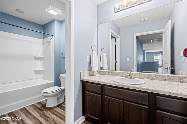 bathroom with visible vents, toilet, wood finished floors, vanity, and washtub / shower combination