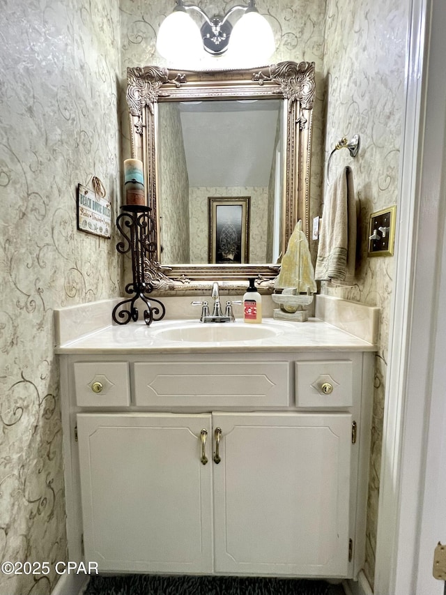 bathroom featuring vanity and wallpapered walls