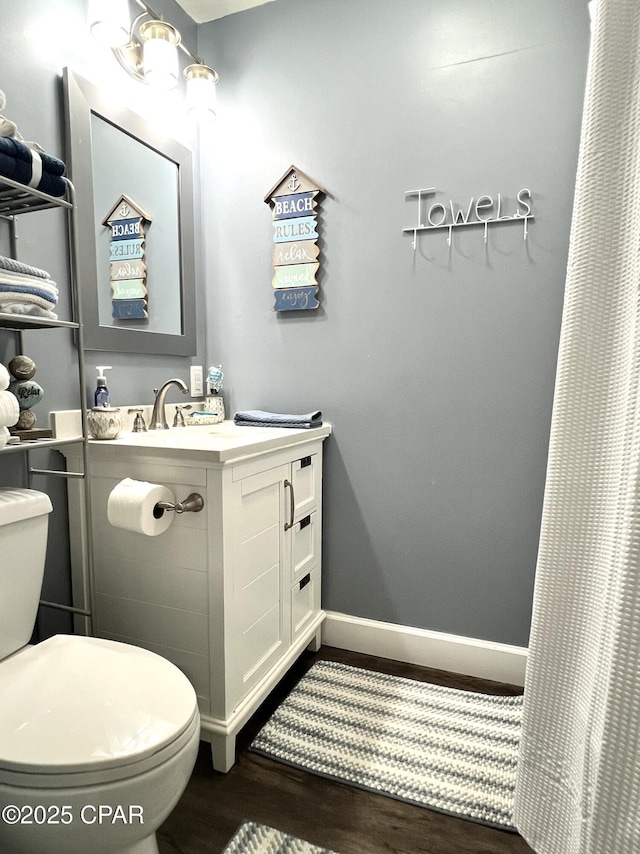 full bath with baseboards, vanity, toilet, and wood finished floors