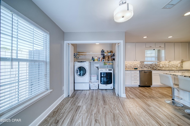 laundry area featuring light wood-style flooring, recessed lighting, visible vents, baseboards, and washing machine and clothes dryer