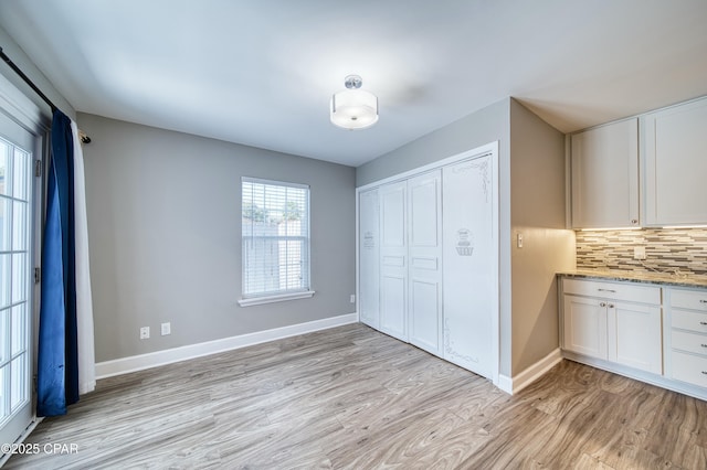 unfurnished bedroom with light wood-style floors, baseboards, and a closet