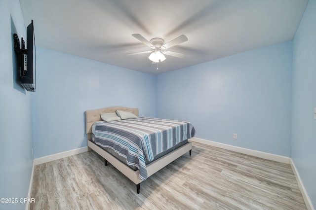 bedroom featuring wood finished floors, a ceiling fan, and baseboards