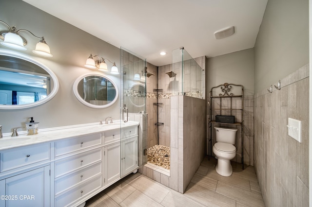 full bathroom featuring walk in shower, a sink, toilet, and double vanity