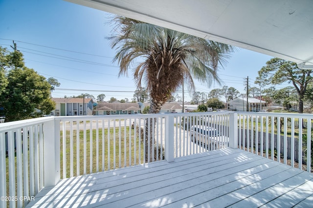 wooden deck featuring a residential view and a lawn