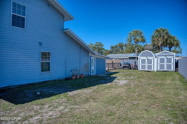 view of yard with a storage shed, a fenced backyard, and an outdoor structure