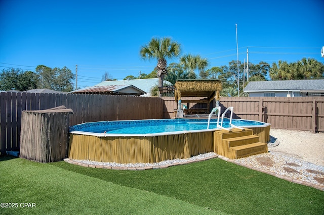 view of pool with a yard, a fenced backyard, and a fenced in pool