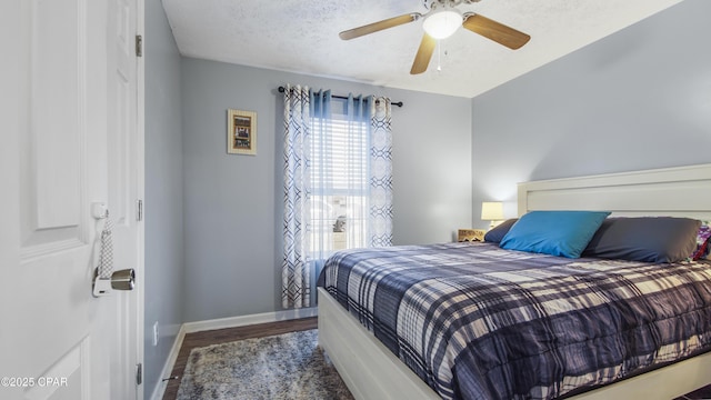 bedroom with a textured ceiling, wood finished floors, a ceiling fan, and baseboards