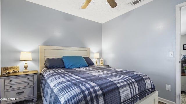 bedroom featuring baseboards, visible vents, ceiling fan, and a textured ceiling